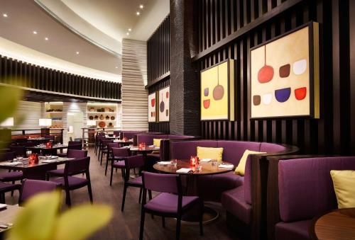 a restaurant with purple chairs and tables and paintings at Hyatt Regency Manila City of Dreams in Manila