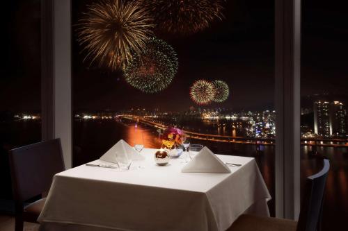 a table with a view of fireworks in the background at Park Hyatt Busan in Busan