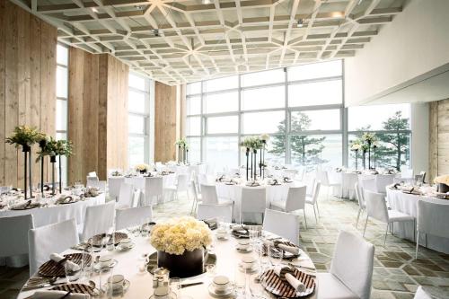 a banquet hall with white tables and white chairs at Park Hyatt Busan in Busan