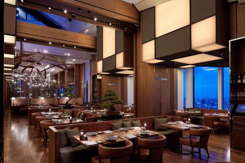 a restaurant with tables and chairs with a view at Andaz Tokyo - A Concept by Hyatt in Tokyo