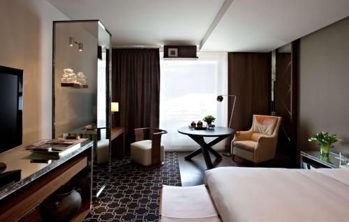 
a hotel room with a couch, chair, table and television at Ararat Park Hyatt Moscow in Moscow
