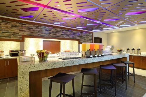 un bar in un ristorante con luci viola sul soffitto di MARINN PLACE Financial District a Città di Panama