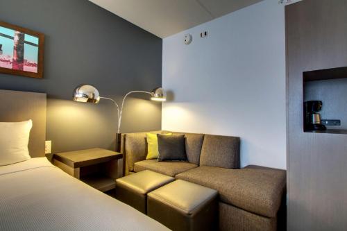 a hotel room with a bed and a couch at Hyatt House Chicago/Evanston in Evanston