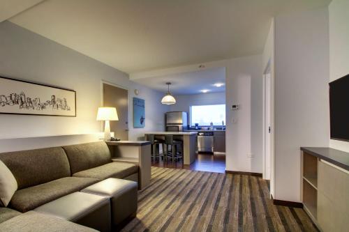 a living room with a couch and a kitchen at Hyatt House Chicago/Evanston in Evanston