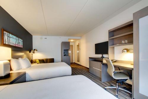 a hotel room with two beds and a desk at Hyatt House Chicago/Evanston in Evanston