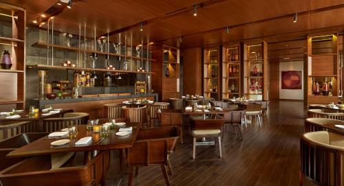 a restaurant with wooden floors and tables and chairs at Hyatt Regency Chandigarh in Chandīgarh