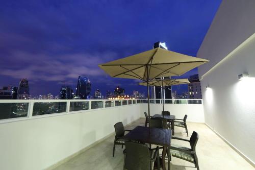 a balcony with a table and chairs and an umbrella at MARINN PLACE Financial District in Panama City