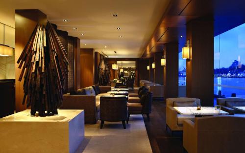 a restaurant with couches and tables and a large window at Park Hyatt Sydney in Sydney