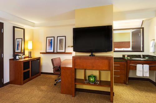 a hotel room with a desk and a flat screen tv at Hyatt Place San Diego-Vista/Carlsbad in Vista