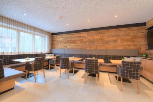 a restaurant with wooden walls and tables and chairs at AKTIV Apartments in Leutasch