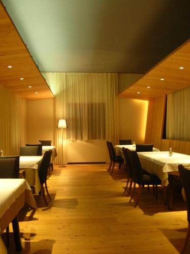 a dining room with white tables and chairs and a room with tables and chairsktop at Gasthof Stegweber in Schwanberg