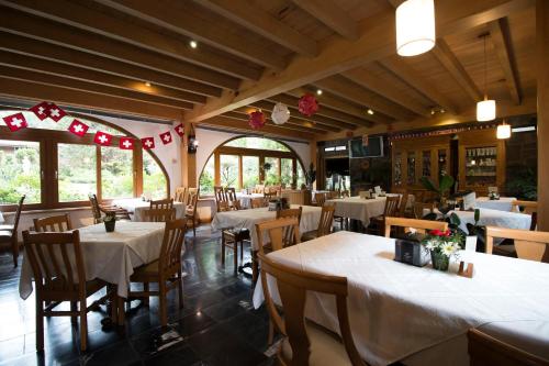 um restaurante com mesas e cadeiras com toalha de mesa branca em Cabaña Suiza em Guatemala