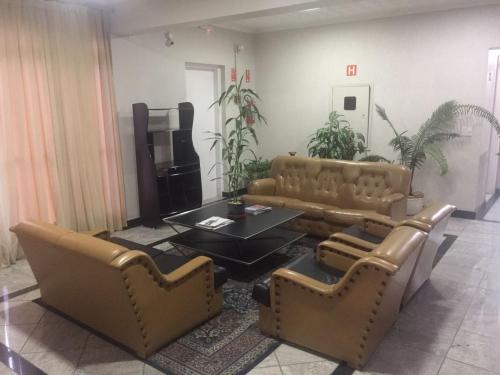 a living room with couches and a coffee table at Ancona Center Hotel in Amparo