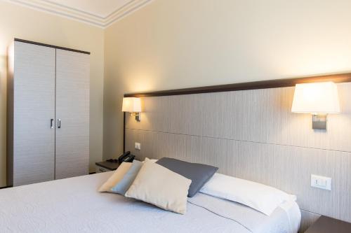 a bedroom with a large white bed with two pillows at Hotel Alpi Resort in Turin