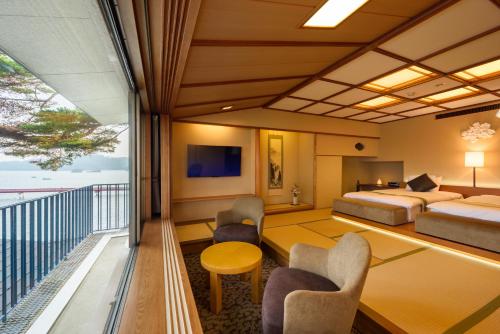 a hotel room with a bed and a balcony at Komatsu-kan Kofu-tei in Matsushima