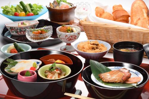 a table with bowls of food and baskets of bread at Komatsu-kan Kofu-tei in Matsushima