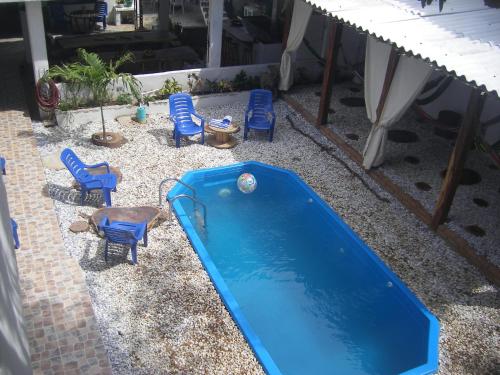 a blue pool with chairs and a table at Hostal Palohe Taganga in Taganga