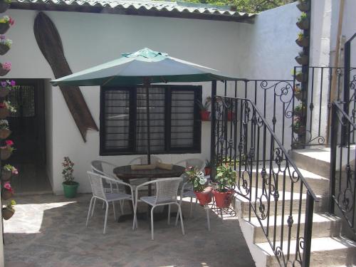 a table and chairs with an umbrella on a patio at Hostal Palohe Taganga in Taganga