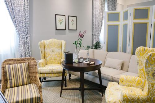a living room with a couch and chairs and a table at Hotel del Parque in Guayaquil