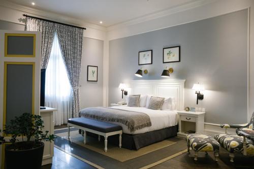 a bedroom with a white bed and a chair at Hotel del Parque in Guayaquil