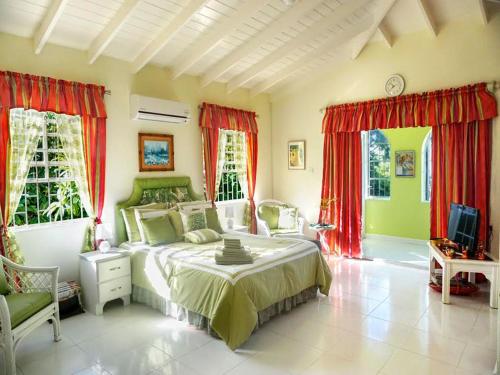 a bedroom with a large bed and red curtains at Spectacular Ocean View Retreat in Saint James