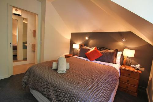 a bedroom with a large bed with orange pillows at Drifters Inn in Hanmer Springs