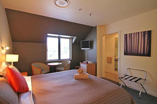 a bedroom with a bed and a window and a television at Drifters Inn in Hanmer Springs