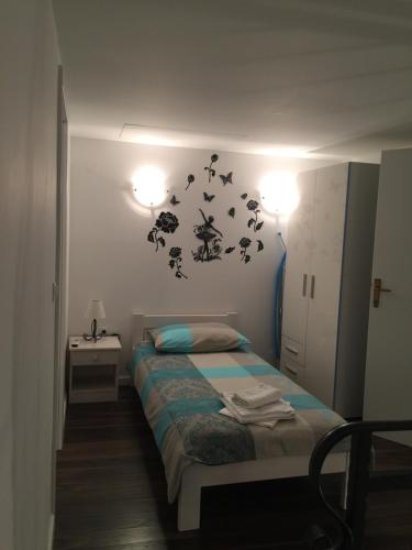a bedroom with a bed and two lights on the wall at Magdalena Vacation House in Punat