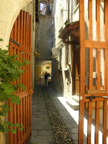 an alley with a person walking down a street at Al vicolo del Gallo in Varallo