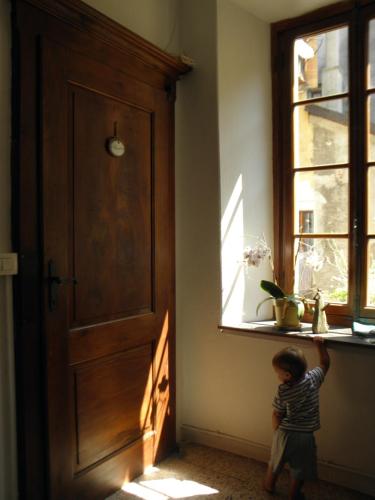 a small child standing in a room looking out a window at Al vicolo del Gallo in Varallo