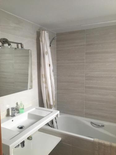 a bathroom with a white tub and a sink at Ses Sivines 25 in Ciutadella