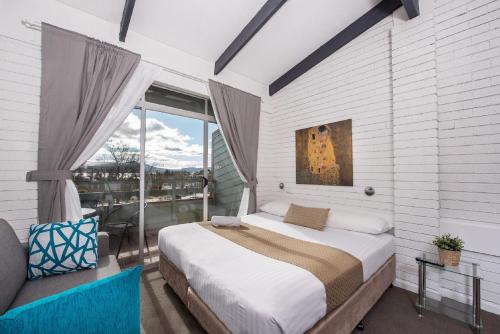 Un dormitorio con una cama grande y una ventana en Alpine Gables, en Jindabyne