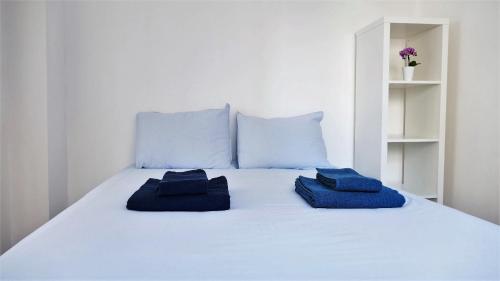 a white bed with two blue pillows on it at EZY Ramos apartment Alfama in Lisbon