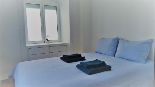 a white bed with two towels on top of it at EZY Ramos apartment Alfama in Lisbon