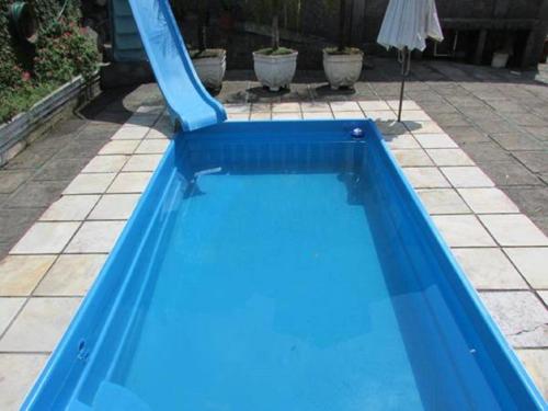 a blue pool with a slide in a yard at Pousada Spa Alto da Serra in Petrópolis