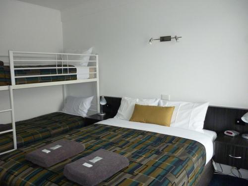 1 dormitorio con 1 cama y 1 litera en Otway Gate Motel, en Colac