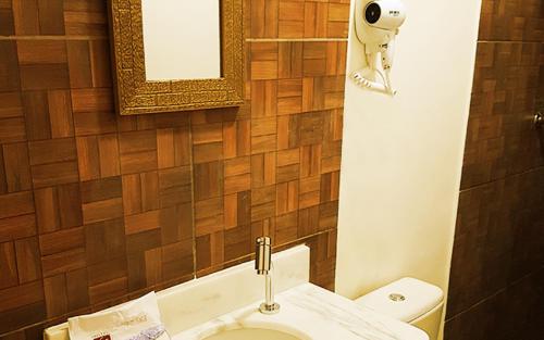 uma casa de banho com um WC e um espelho. em Hotel Flor em São Paulo