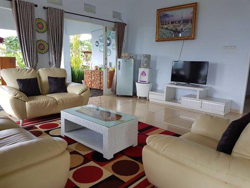a living room with two couches and a tv at Villa Jidah in Gegarbensang