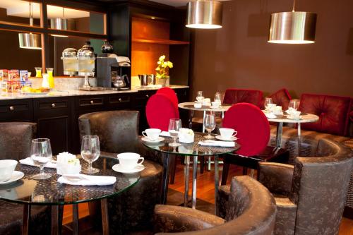 a restaurant with tables and chairs with red chairs at La Inmaculada Hotel in Guatemala