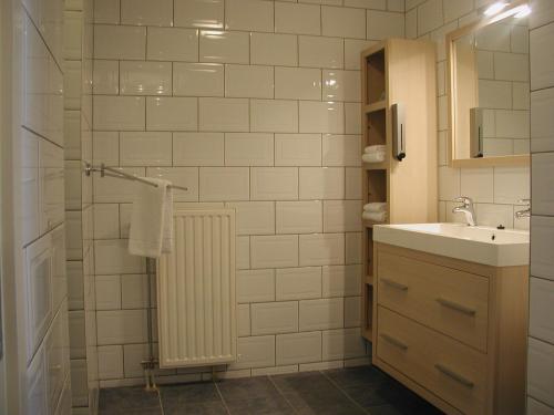 y baño blanco con lavabo y ducha. en Hotel Studio Bosch Duin Strand, en Den Helder