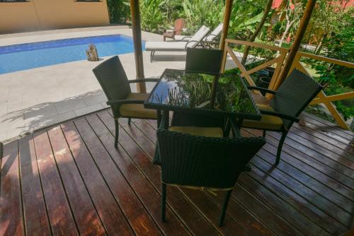 a patio with a table and chairs next to a pool at Hotel El Mono Feliz in Ojochal