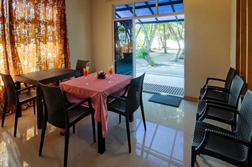 a dining room with a table and chairs and a window at Fulidhoo Ihaa Lodge in Fulidhoo