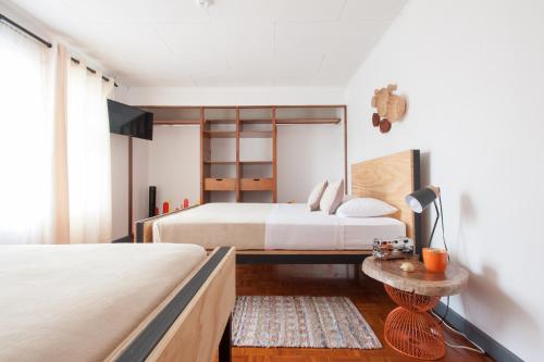 a bedroom with two beds and a table at Capital Hostel de Ciudad in San José