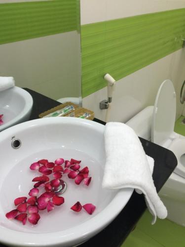 a bathroom with a sink with pink flowers in it at Hue Lovely Homestay in Hue