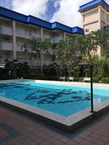 a swimming pool in front of a hotel at Kenting My Way B&B in Nanwan