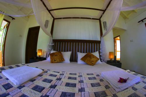 Un dormitorio con una cama grande con dos almohadas. en Citron Villa, en Koggala