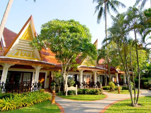 a house with palm trees in front of it at Santhiya Koh Chang Resort in Ko Chang