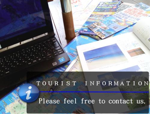 a laptop computer sitting on top of a table with books at Hotel Sun Queen in Naha