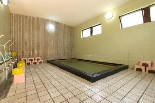 a bathroom with a pool in the middle of a room at Kannabe Highland Hotel in Toyooka