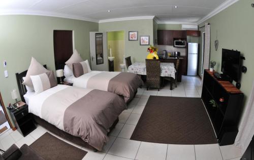 una camera d'albergo con due letti e una cucina di Summer Garden Guest House (The Flower Box) a Benoni